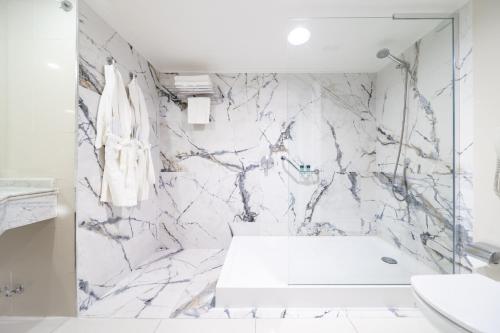 a white bathroom with a marble wall at Wyndham Garden Santiago Kennedy in Santiago
