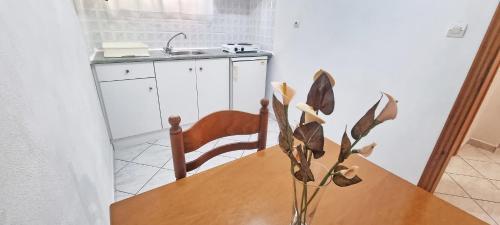 a kitchen with a wooden table with a vase on it at Alma Apartments in Loutra Edipsou