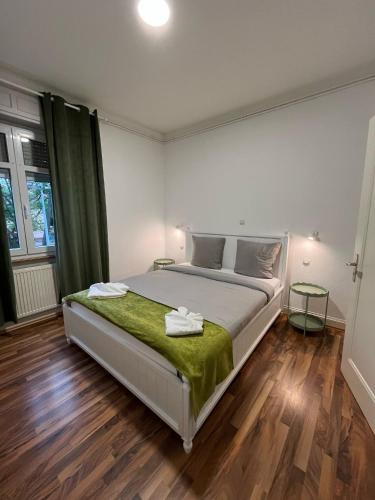 a bedroom with a large bed with a green blanket at City APPARTEMENT EN 3 Lys in Saint-Louis