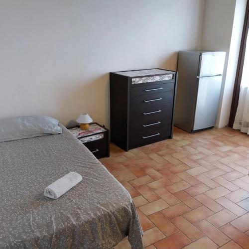 a bedroom with a bed and a dresser and a refrigerator at La Bella Vista in Collazzone