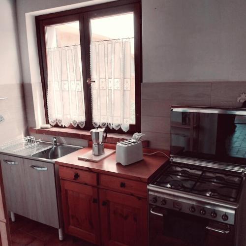 a kitchen with a stove and a sink and a window at La Bella Vista in Collazzone