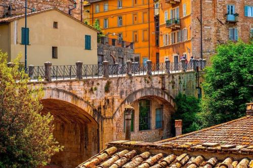 an old bridge with people standing on top of it at La Bella Vista in Collazzone