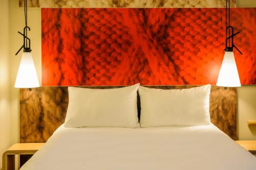 a bedroom with a bed with two lights above it at Ibis Hamburg City in Hamburg