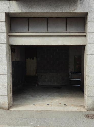 an empty garage with a brick wall at Votre Refuge Urbain Logement Complet pour Étudiants et Pros in Fougères