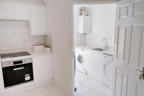 a white kitchen with a sink and a washing machine at Apsley Way, 5 bed 4 bathroom house in Thornaby on Tees