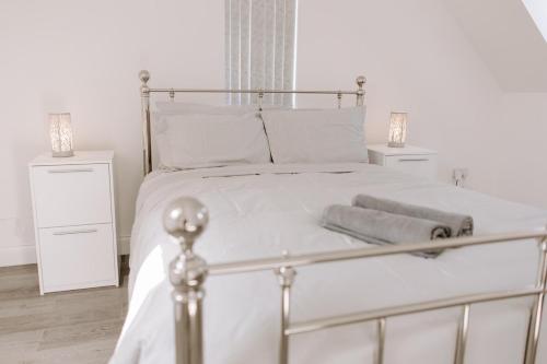 a white bed with two night stands and two lamps at Apsley Way, 5 bed 4 bathroom house in Thornaby on Tees