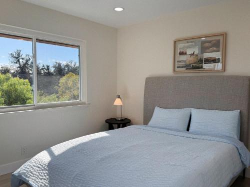 a bedroom with a bed and two windows at Vista Haven in Santa Babara in Santa Barbara