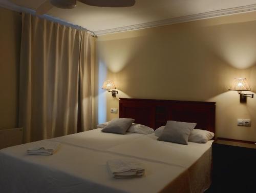 a bedroom with a large bed with two towels on it at Cabalo Furado Tui in Tui