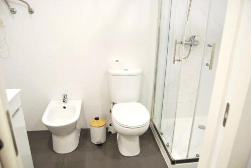 un bagno bianco con wc e doccia di Blue House in the Old Town Setúbal a Setúbal