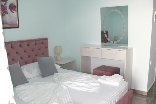 a bedroom with a white bed and a mirror at Hotel Erviliano in Borsh