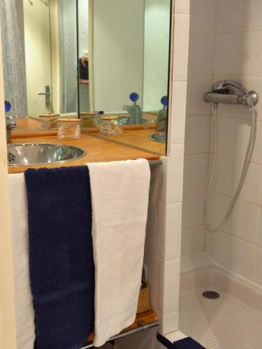 une salle de bain avec un lavabo, un miroir et des serviettes dans l'établissement Appart neuf et cosy 2 personnes center port Cap d'Agde, au Cap d'Agde