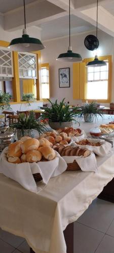 a table topped with lots of different types of bread at Pousada Fortaleza in Paraty