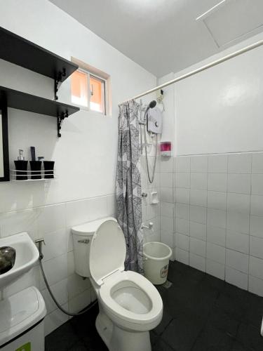 a bathroom with a toilet and a sink and a shower at Your second home in Tagbilaran in Tagbilaran City