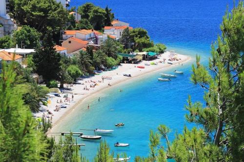 a beach with people and boats in the water at Golden Horizon Suite in Stanići