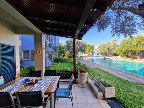 a patio with a table and chairs and a pool at Porto Blue Horizon in Pefkohori