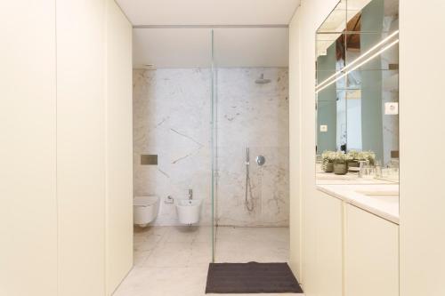 a bathroom with a glass shower stall and a toilet at Central Bedroom in Shared House in Chiado - Historic Center of Lisbon in Lisbon