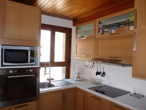 une cuisine avec un évier et un micro-ondes dans l'établissement Bel appartement lumineux dans maison de village, à La Salle Les Alpes