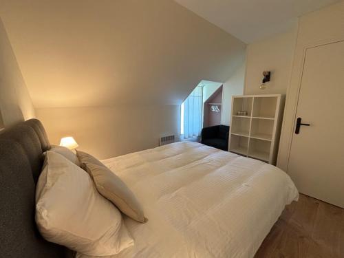 a bedroom with a large bed with white sheets and pillows at Stone House in Plélan-le-Petit