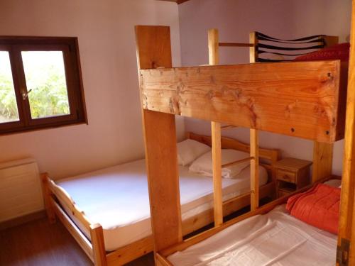 deux lits superposés dans une chambre avec fenêtre dans l'établissement Bel appartement lumineux dans maison de village, à La Salle Les Alpes