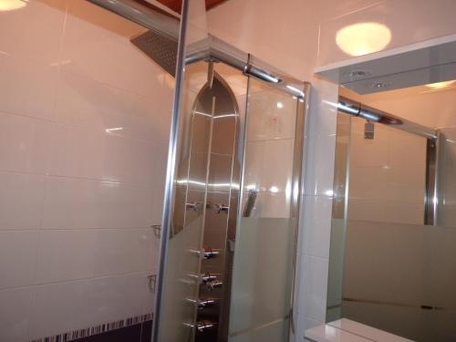 une douche avec une porte vitrée dans une salle de bain dans l'établissement Bel appartement lumineux dans maison de village, à La Salle Les Alpes