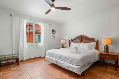 Un dormitorio con una cama y un ventilador de techo. en Golf Course Access Balcony Infinity Pool, en Fajardo