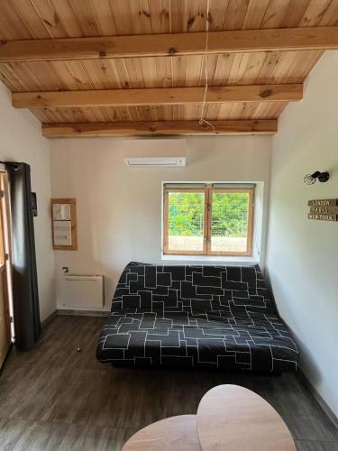 une chambre avec un lit noir dans une pièce dans l'établissement Chalet détente, à Montaut