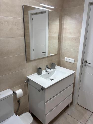 a bathroom with a sink and a mirror and a toilet at Casa Serena in Los Cristianos