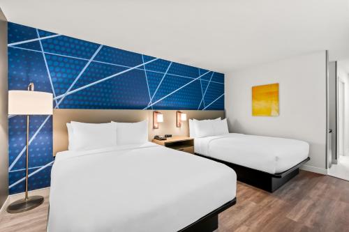 a hotel room with two beds and a blue wall at Comfort Inn & Suites Salt Lake City I-80 I-15 Downtown in Salt Lake City