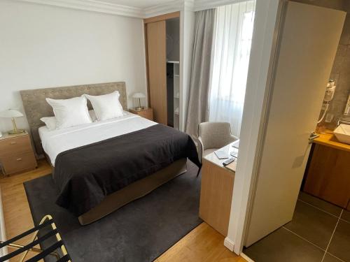 a hotel room with a bed and a window at Hôtel Victor Hugo in Pontorson