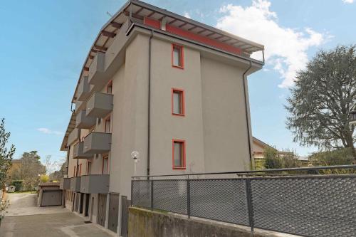 a building with red windows and a fence at A10 Arcobaleno Rho-Fiera -Laghi & MXP FINELY RENOVATED APARTMENT in Cesate