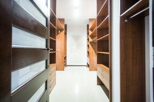 a walk in closet with wood cabinets and a hallway at Europejski Boutique Hotel in Radom