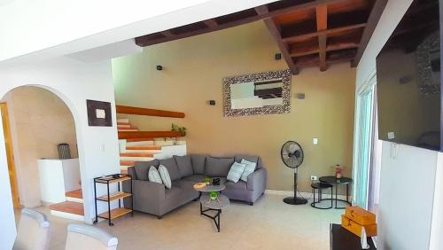 a living room with a couch and a table at Sikinos Holiday Home in Telchac Puerto