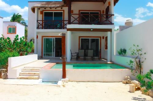 a house with a swimming pool in front of it at Sikinos Holiday Home in Telchac Puerto