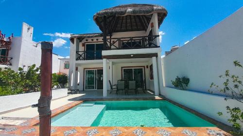 a house with a swimming pool in front of it at Sikinos Holiday Home in Telchac Puerto