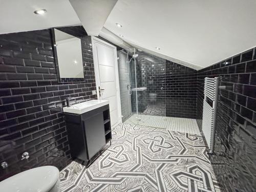 une salle de bain en noir et blanc avec une douche et un lavabo dans l'établissement villa lucienne, à Vallauris