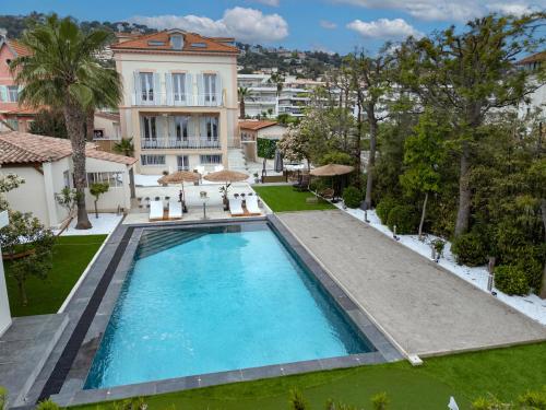- une vue sur la piscine en face d'un bâtiment dans l'établissement villa lucienne, à Vallauris