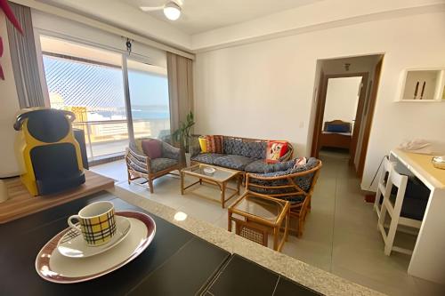 a living room with a couch and a table at Brisa à Beira-Mar: Desfrute do melhor no Gonzaga in Santos