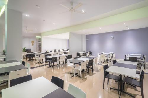 an empty restaurant with tables and chairs at Vapa Hotel - SHA Extra Plus in Phuket Town