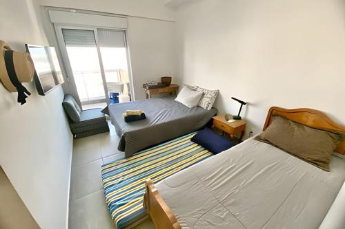 a small bedroom with two beds and a window at Brisa à Beira-Mar: Desfrute do melhor no Gonzaga in Santos