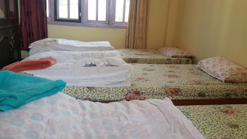 a group of three beds in a room at Friendship Home Stay in Kathmandu