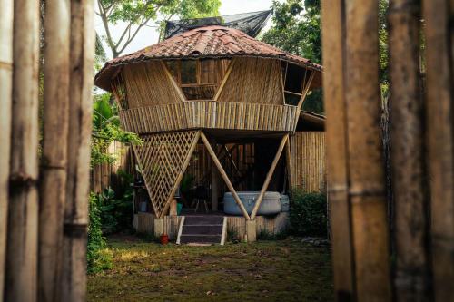 a small bamboo house with a thatched roof at Bambuk Bio Chalet Uvita Beach Front in Uvita
