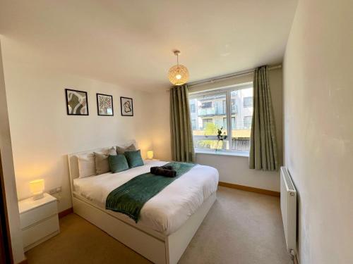 ein Schlafzimmer mit großem Bett und Fenster in der Unterkunft Cosy 2 Bed 2 Bath Apartment with Free Parking Smart TV Netflix and WIFI in Dartford 10 min to Bluewater in Dartford