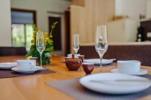 a wooden table with plates and wine glasses on it at Landhaus Valfontana in Vandans