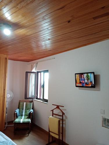 a living room with a tv on the wall at Pêssego - AL in Arouca