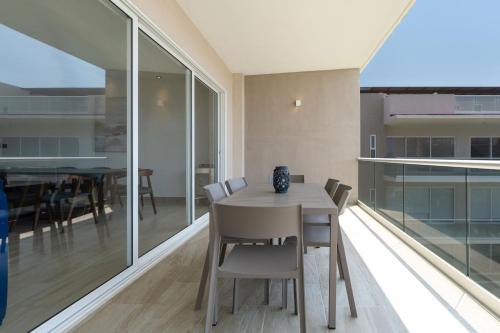 a dining room with glass walls and a table and chairs at Punta Arena - Beach - Pool - WiFi - Jacuzzi in Acapulco