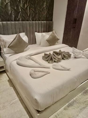 a white bed with towels and bows on it at Shri Shyam Hotel, Near Harkipauri in Haridwār