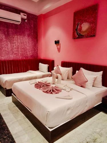 two beds in a room with pink walls at Shri Shyam Hotel, Near Harkipauri in Haridwār