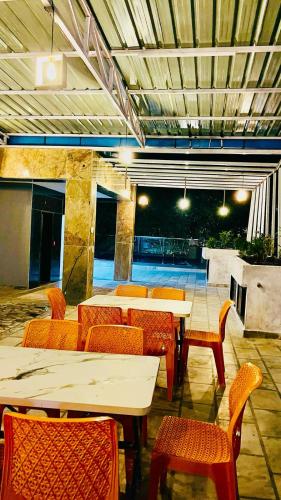 a restaurant with tables and chairs and a tennis court at Shri Shyam Hotel, Near Harkipauri in Haridwār