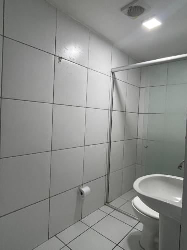 a white bathroom with a toilet and a sink at Hotel Pousada Baturité FORTALEZA in Fortaleza