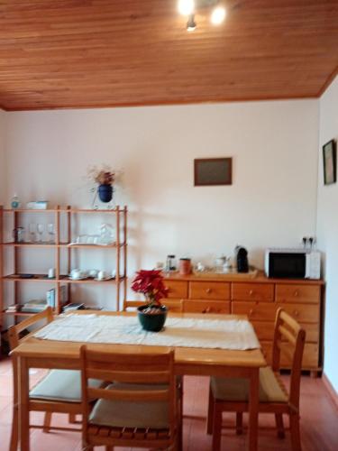 a dining room with a table and chairs and a kitchen at Pêssego - AL in Arouca